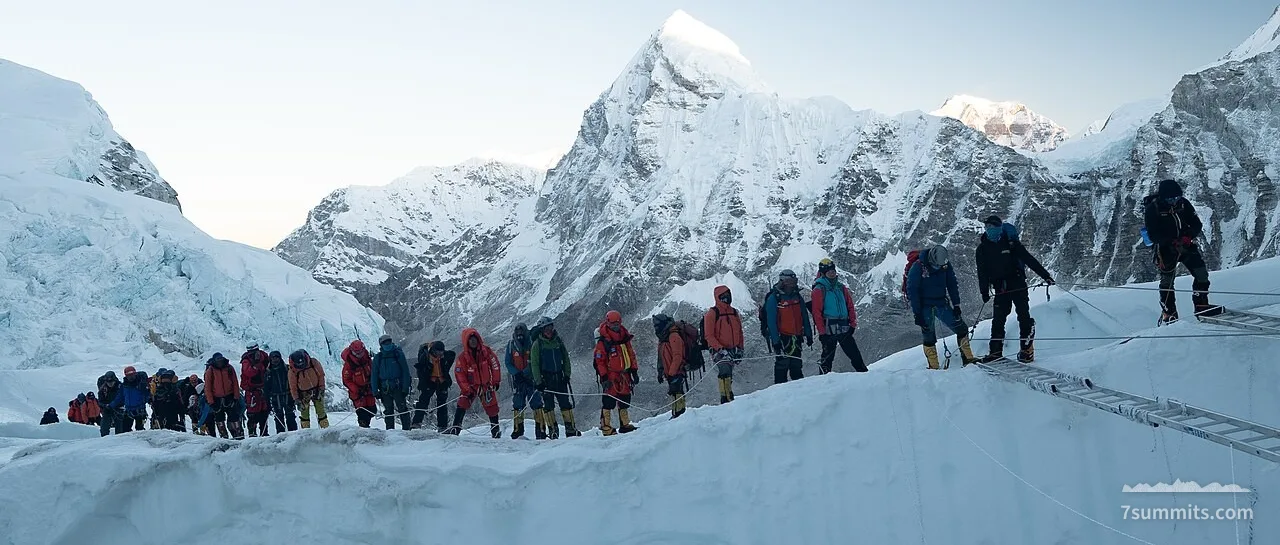 Climbers queue to cross a ladder over a crevasse in the Khumbu Icefall on Everest