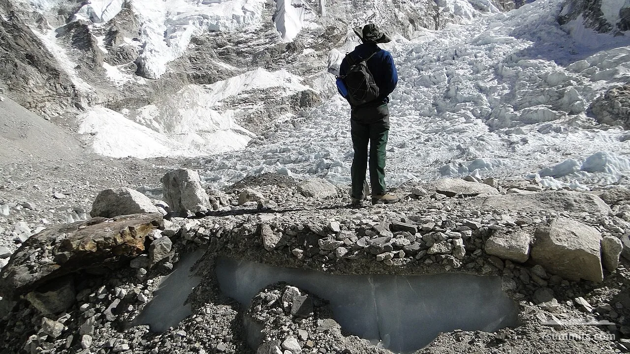 A person stands on the Khumbu glacier at Everest Base Camp, Nepal, with the Khumbu Icefall behind.