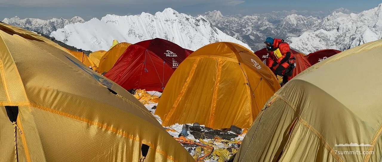 Everest Camp IV at South Col, showing tents and debris amid high-altitude mountain scenery
