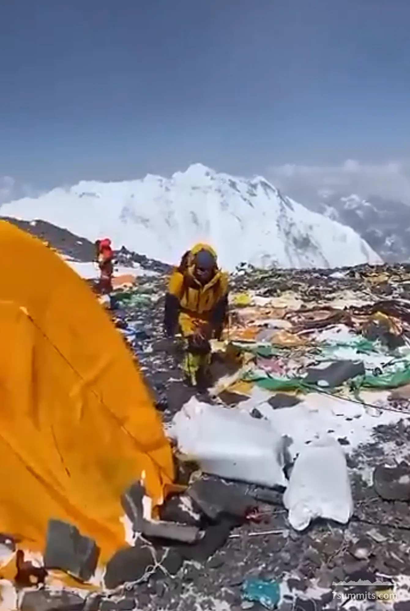 Tent and climber on South Col, Everest, surrounded by trash