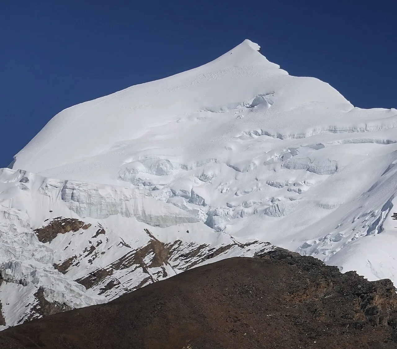 Snow-covered summit of Himlung Himal seen from its base camp