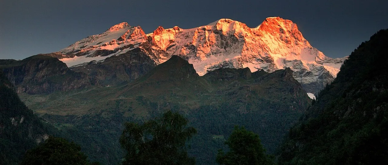 Monte Rosa massif viewed from Valsesia at sunrise with glowing peaks