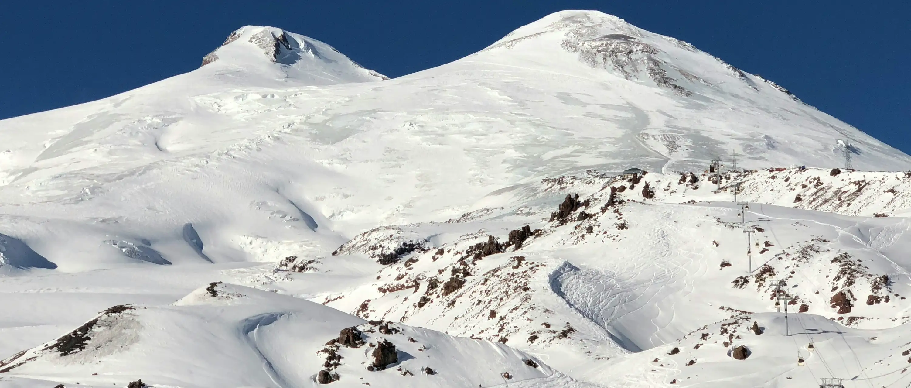 elbrus — snow covered mountain under blue sky