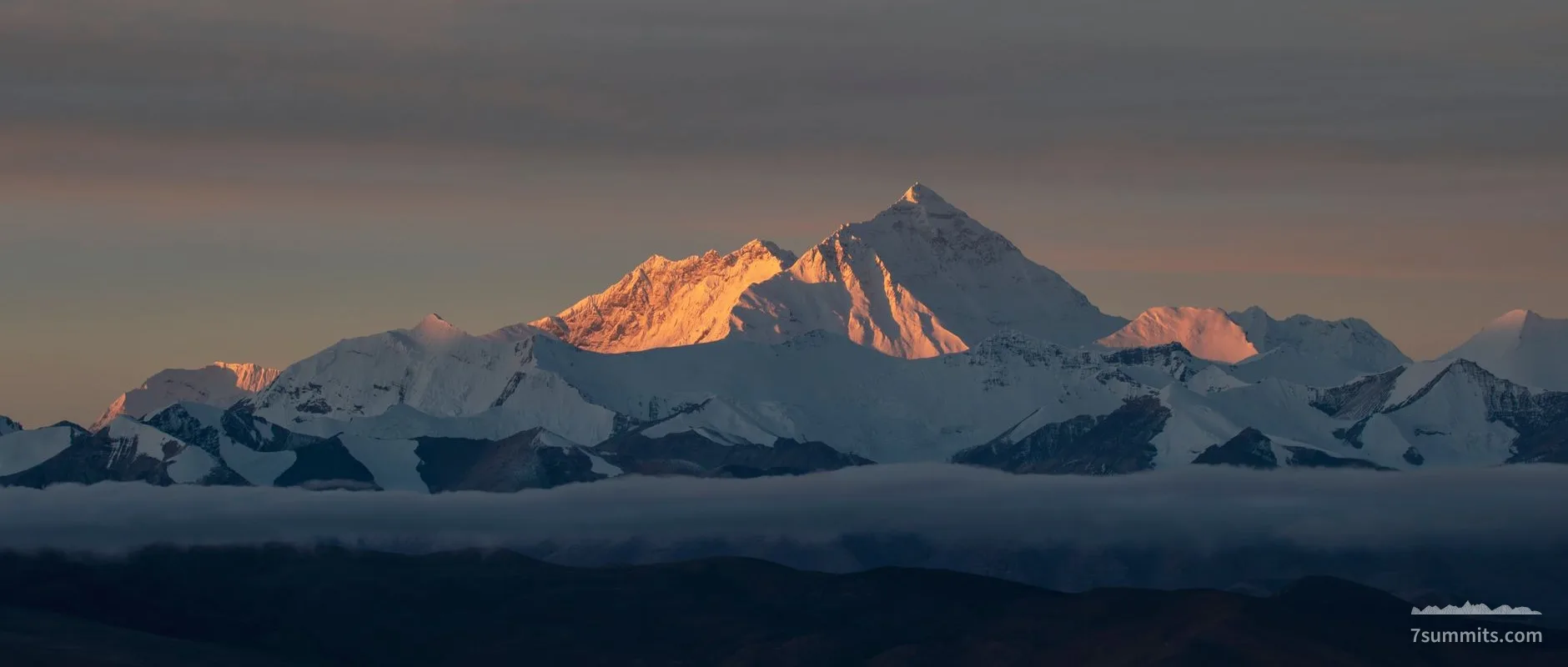 Stunning sunrise view of Mount Everest in the Himalayas with warm light on the snow-capped peaks.